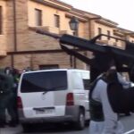 Imagen de un agente armado, cubriendo a varios compañeros durante un registro