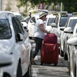Una viajera pasa entre los taxis aparcados / Efe