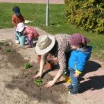 Sobre estas líneas, Belén enseña a los niños que tiene a su cargo a plantar un pequeño huerto para que aprendan el desarrollo de la naturaleza