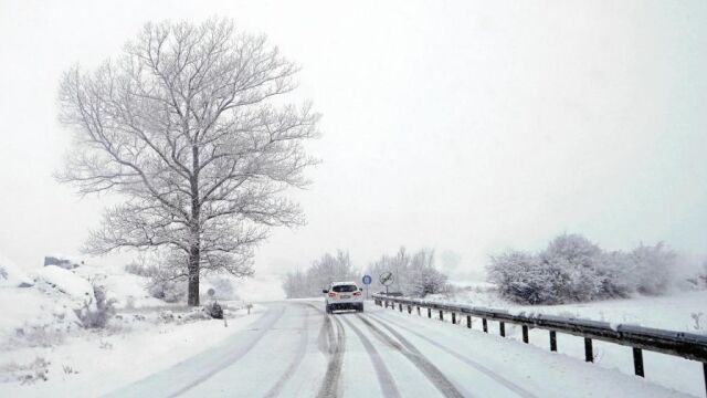Un vehículo circula por la carretera A-226 entre Teruel y Cedrillas que está cubierta por la nieve caída en las últimas horas