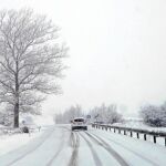 Un vehículo circula por la carretera A-226 entre Teruel y Cedrillas que está cubierta por la nieve caída en las últimas horas