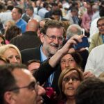 El presidente del Gobierno, Mariano Rajoy, se fotografía con unos asistentes esta tarde a la Convención Nacional del PP