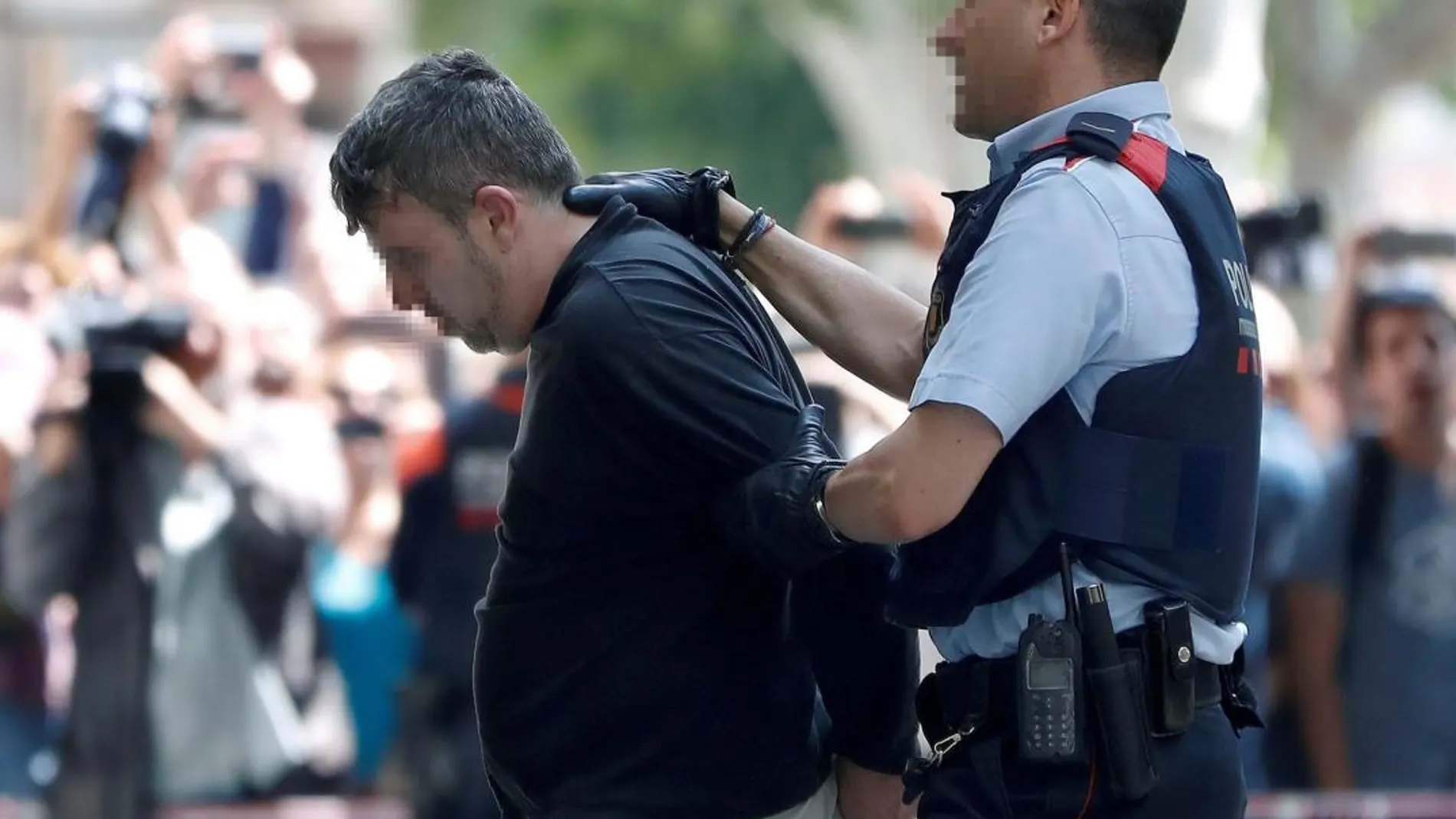 Los Mossos d'esquadra con el detenido a la llegada a la vivienda donde presuntamente mató a niña de 13 años ayer en Vilanova i la Geltrú (Barcelona)