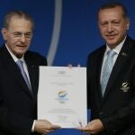 El primer ministro turco recibe del presidente del COI, Jacques Roge, un diploma.