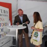 Arturo Pérez-Reverte, estilográfica en mano, dispuesto a rubricar uno de sus libros a una lectora