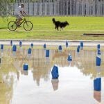 Un hombre y su perro pasean junto a la obra «Lagunas», de la artista norteamericana Maura Sheehan