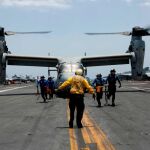 Varios marinos quitando cuñas a un MV-22 Osprey, del escuadrón Medium Tiltrotor 264 de la Marina
