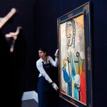 Una empleada de Sotheby's coloca la pintura "Hombre con una pipa", de Pablo Picasso, en la exposición de Arte Impresionista y Moderno en Londres / Foto: Efe