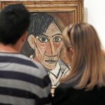 Dos visitantes de la muestra contemplan un autorretrato de Picasso de 1907