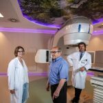 El gerente del Hospital de Fuenlabrada, junto a la doctora Mariví de Torres y el paciente de radioterapia Celso, junto al acelerador lineal donado por Amancio Ortega. Foto. Gonzalo Pérez