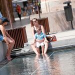 Varios turistas se refrescan en la plaza de la Almoina durante el pasado verano