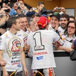 Marc, con la camiseta de campeón del mundo, es felicitado por su hermano Álex, con Santi Hernández, jefe de mecánicos, detrás