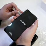 Un vendedor enseña un modelo P30 de Huawei a un cliente en Pekín