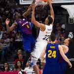 El ala-pívot estadounidense del FC Barcelona Lassa Chris Singleton (i) lucha con Edy Tavares, del Real Madrid / Efe