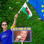 Un partidario de no salir de la UE junto a un cartel recordando las mentiras de Nigel Farage durante la campaña del Brexit / Reuters