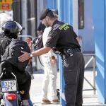 Un agente palpa la mochila de un motorista en la Verja con Gibraltar, mientras el SUP y la AUGC denuncian los acosos