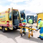 Dos técnicos sanitarios de Summa trasladan a un herido simulado a una ambulancia