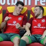 El internacional galés Gareth Bale, quien ha fichado recientemente por el Real Madrid, bromea en el banquillo con un compañero durante el partido Macedonia-Gales