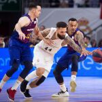El sueco Jeffery Taylor (c), del Real Madrid, lucha con el francés Thomas Heurtel (i) y el húngaro Ádám Hanga, ambos del FC Barcelona Lassa, durante el primer partido de la final de la Liga ACB