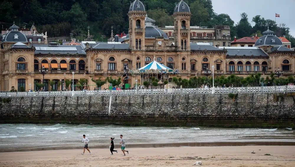 Varias personas corren por la playa de La Concha de San Sebastián. EFE/Javier Etxezarreta