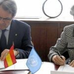 Mas, con la directora general de la Unesco en la firma del protocolo, ayer en París, con la bandera española sobre la mesa