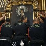 Integrantes del cuerpo de Bomberos durante la bajada del cuadro de la Virgen de la Paloma del año pasado
