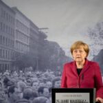 La canciller alemana, Angela Merkel, delante de la histórica fotografía de la caída del muro de Berlín