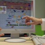 En la imagen, un médico muestra a un paciente el proceso de la esclerosis múltiple