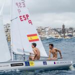 Los regatistas en su barco, con la bahía de Las Palmas de Gran Canarias de fondo