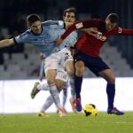 El defensa del Celta Andreu Fontàs (i) pugna por un balón con el delantero del Osasuna Oriol Riera (d).