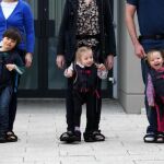 Tres personas prueban el arnés que permite a sus hijos caminar con ellos