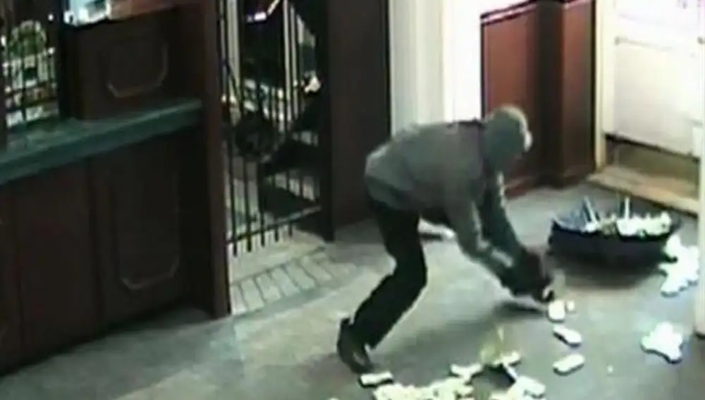 Un ladrón recoge el dinero robado.