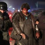 Un policía ayuda a trasladar a uno de los heridos