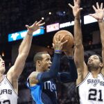 El jugador brasileño de San Antonio Spurs Tiago Splitter (y) y Tim Duncan (d) intentan bloquear un lanzamiento de Monta Ellis