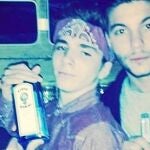 La imagen muestra a Rocco (en el centro) sosteniendo una botella de ginebra