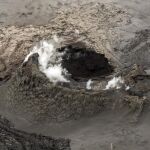 Vista aérea de unas nubes de humo y vapor saliendo de una fisura en una zona cubierta por lava al norte del glacial Vatnajokull en Islandia.