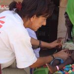 Una voluntaria de Médicos Sin Fronteras examina a un niño en el campo de refugiados de El Fasher (Darfur)