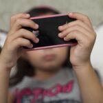 Una niña manejando su smartphone