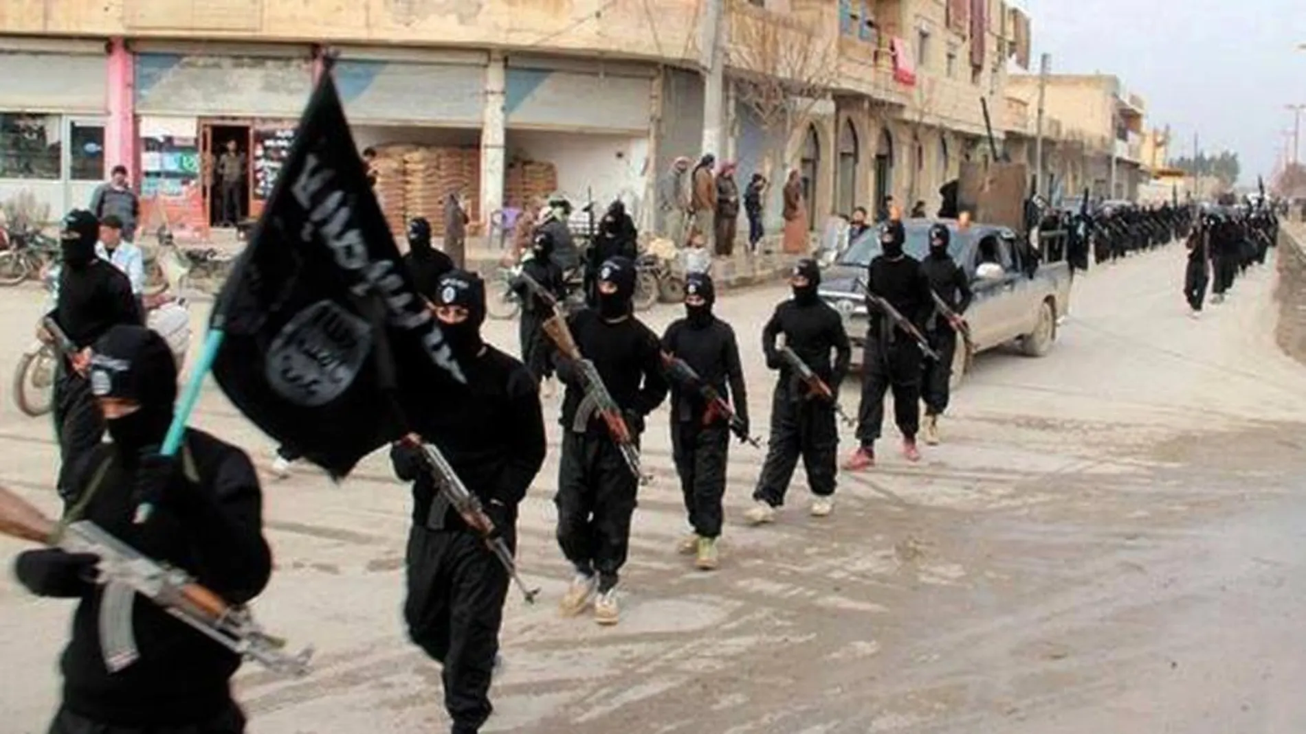 Miembros del Estado Islámico desfilan por una calle de la ciudad siria de Raqa en 2019