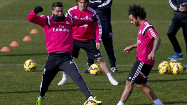 El delantero portugués del Real Madrid, Cristiano Ronaldo (i), disputa la pelota al brasileño Marcelo (d), durante el entrenamiento.