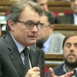 El presidente de la Generalitat, Artur Mas, responde a una pregunta ante la mirada del líder de ERC, Oriol Junqueras