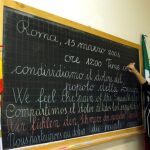 Un estudiante de secundaria escribe en una pizarra en italiano, español, inglés,a lemán y francés en recuerdo a los españoles por los atentados del 11-M