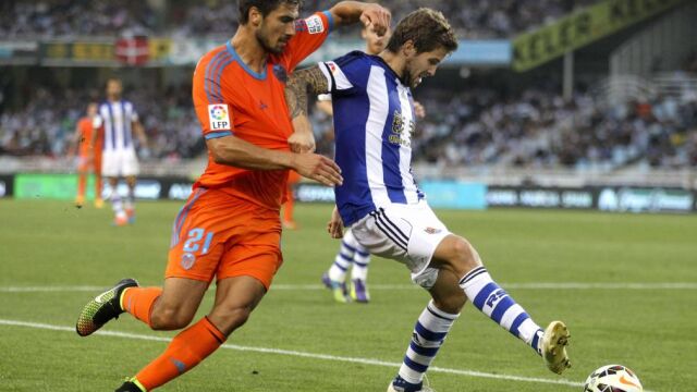 El centrocampista portugués del Valencia André Gomes lucha un balón con el defensa de la Real Sociedad Íñigo Martínez