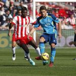 El centrocampista portugués del Sevilla, Daniel Carriço (c), controla un balón ante el centrocampista ghanés del Almería, Thomas Partey (i).