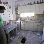Una mujer israelí mira los daños provocados por un cohete en su casa