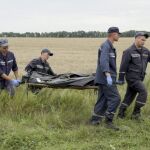 Miembros del servicio de rescate trasladan uno de los cadáveres del avión siniestrado.