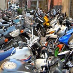 En la imagen, una calle con multitud de motocicletas aparcadas