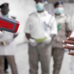 Sanitarios nigerianos toman la temperatura en el aeropuerto de Lagos a los viajeros recién llegados