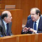 El presidente de la Junta, Juan Vicente Herrera, habla con Tomás Villanueva durante un Pleno de las Cortes