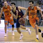 El ala-pivot del Valencia Basket, Pau Rivas (d), bota el balón ante el alero del F. C. Barcelona, Alex Abrines